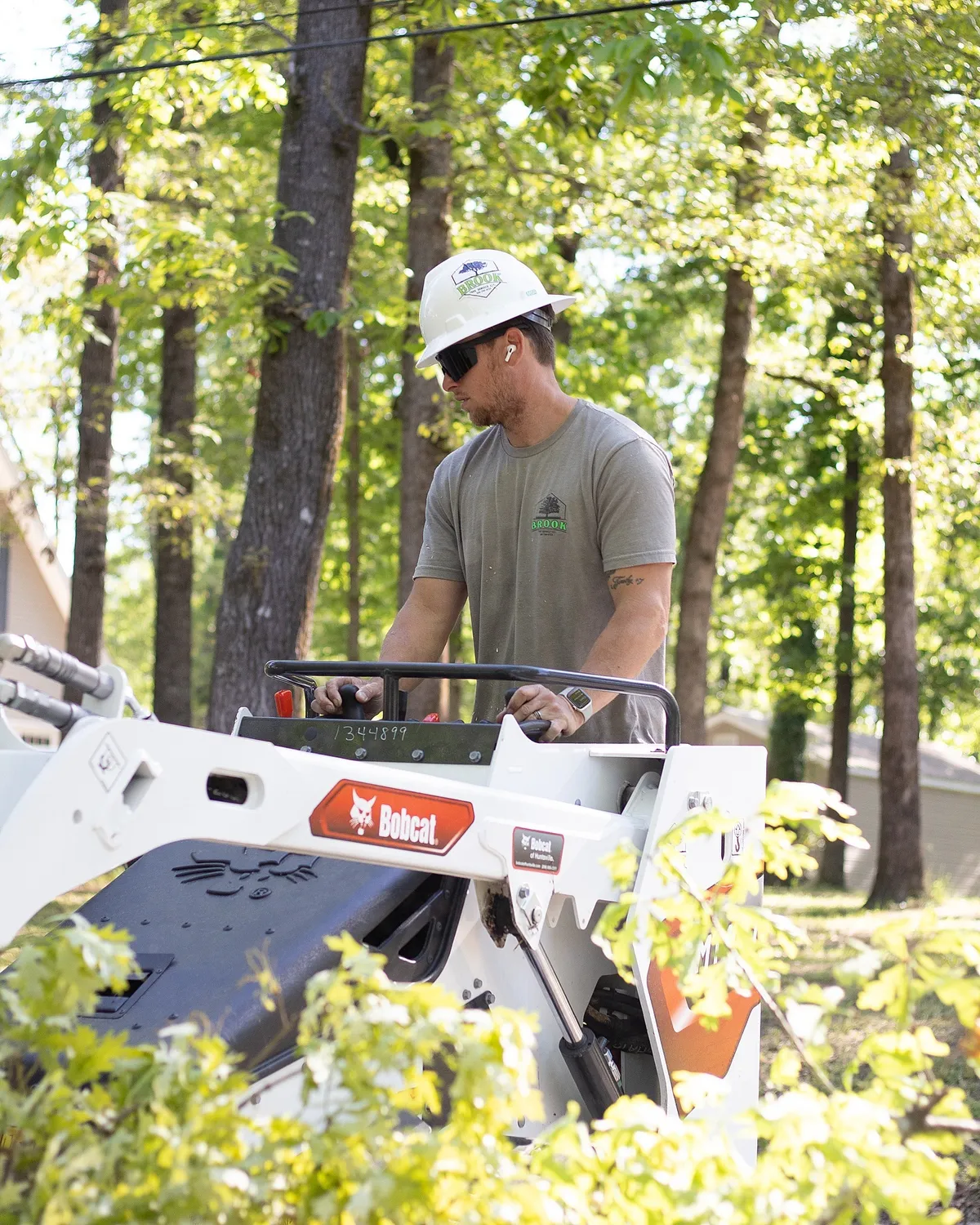 Crew operating Bobcat equipment for debris removal and cleanup